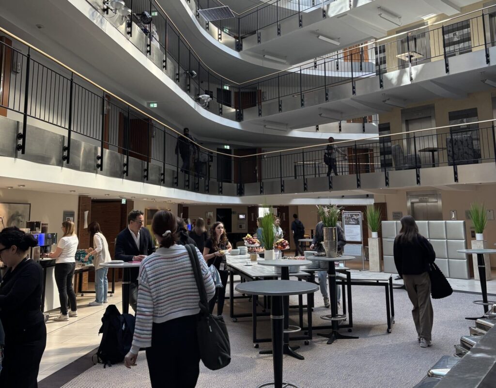 Hotellobby mit Sicht auf mehrere Stockwerke sowie einem Event bei welchem mehrere Menschen bereits warten.